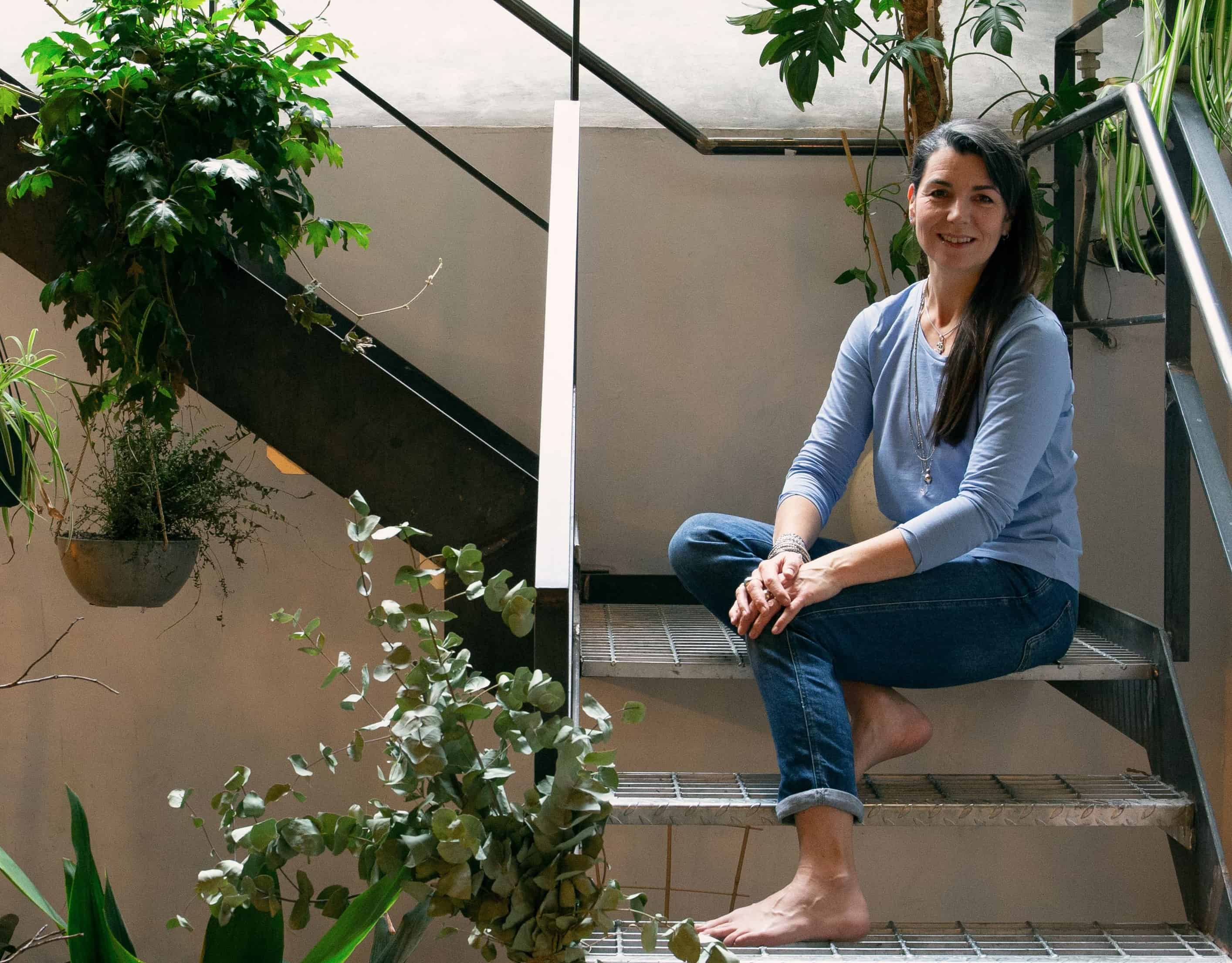 Deborah sitting on stairs with plants